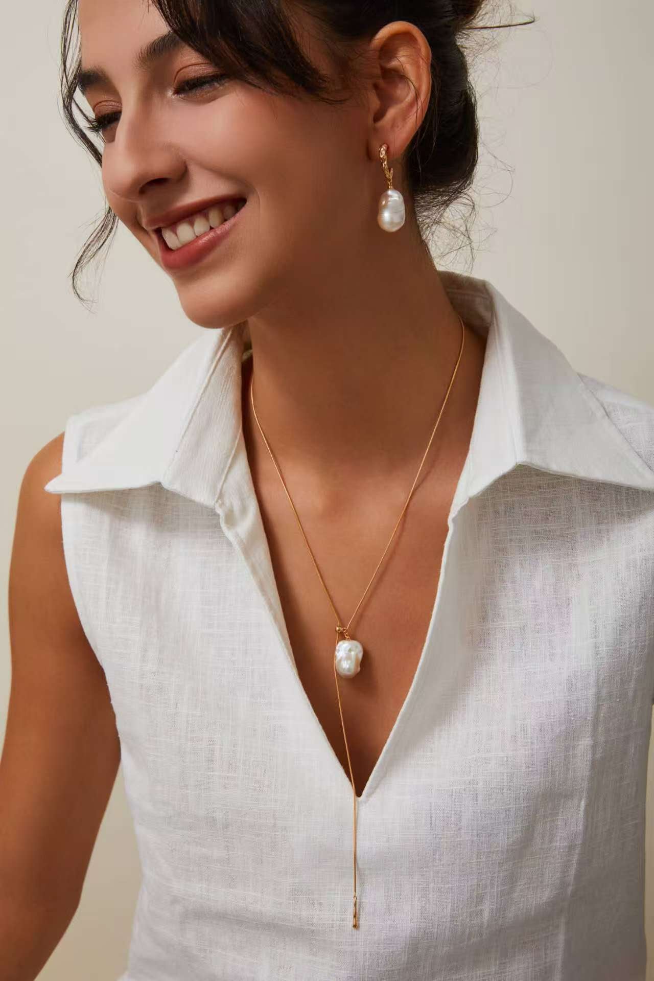 Gold baroque pearl pendant necklace worn with thin adjustable chain and tassel