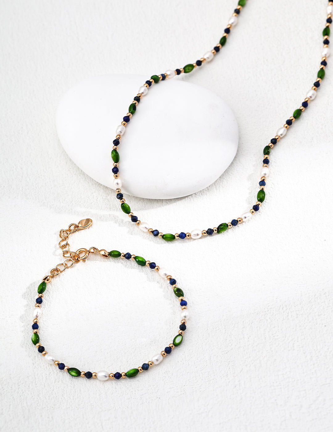 Bead pearl necklace with green and navy bead pattern and gold-tone chain, clasp visible