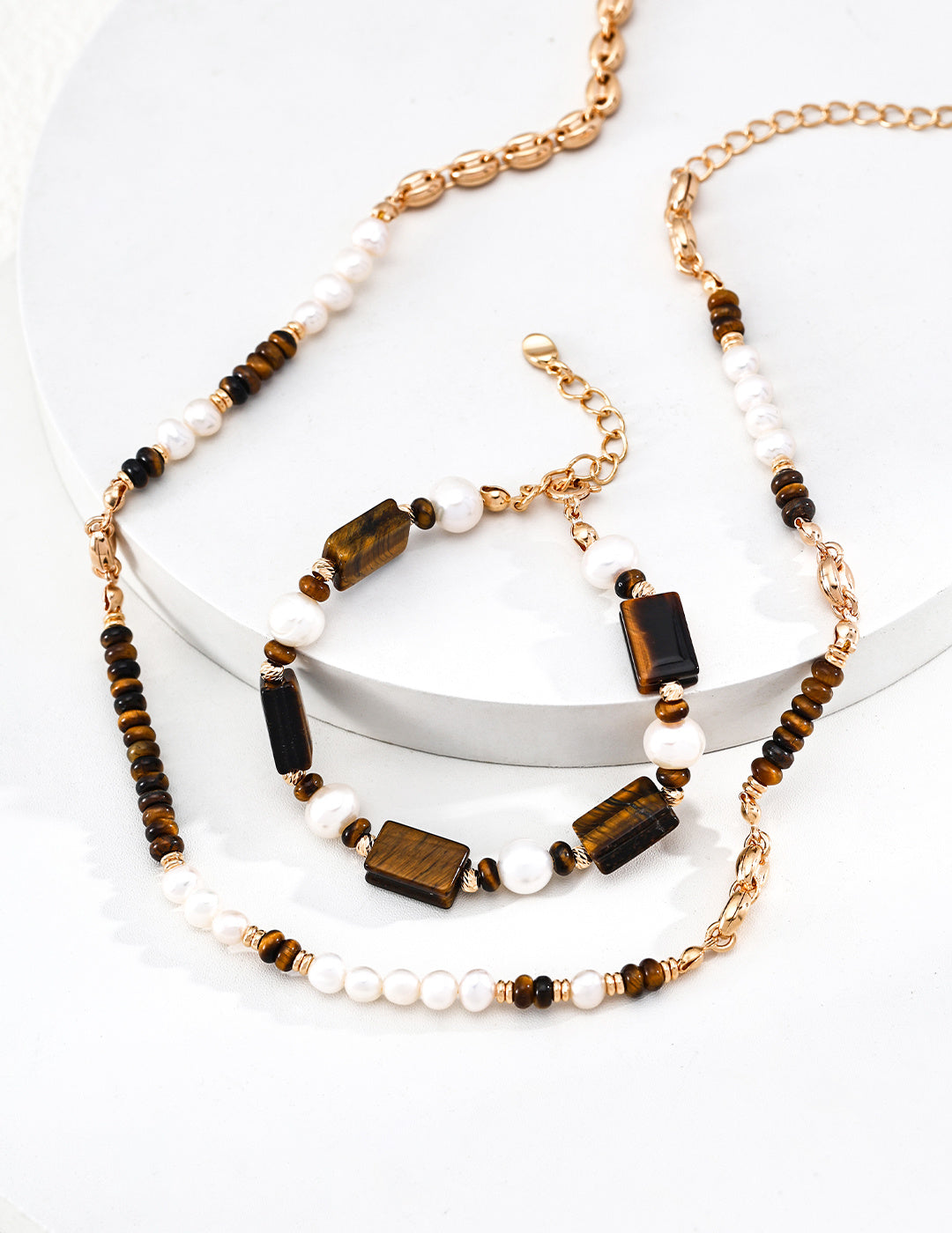 Set of gold-tone tiger eye and white pearl beaded bracelets with chain links