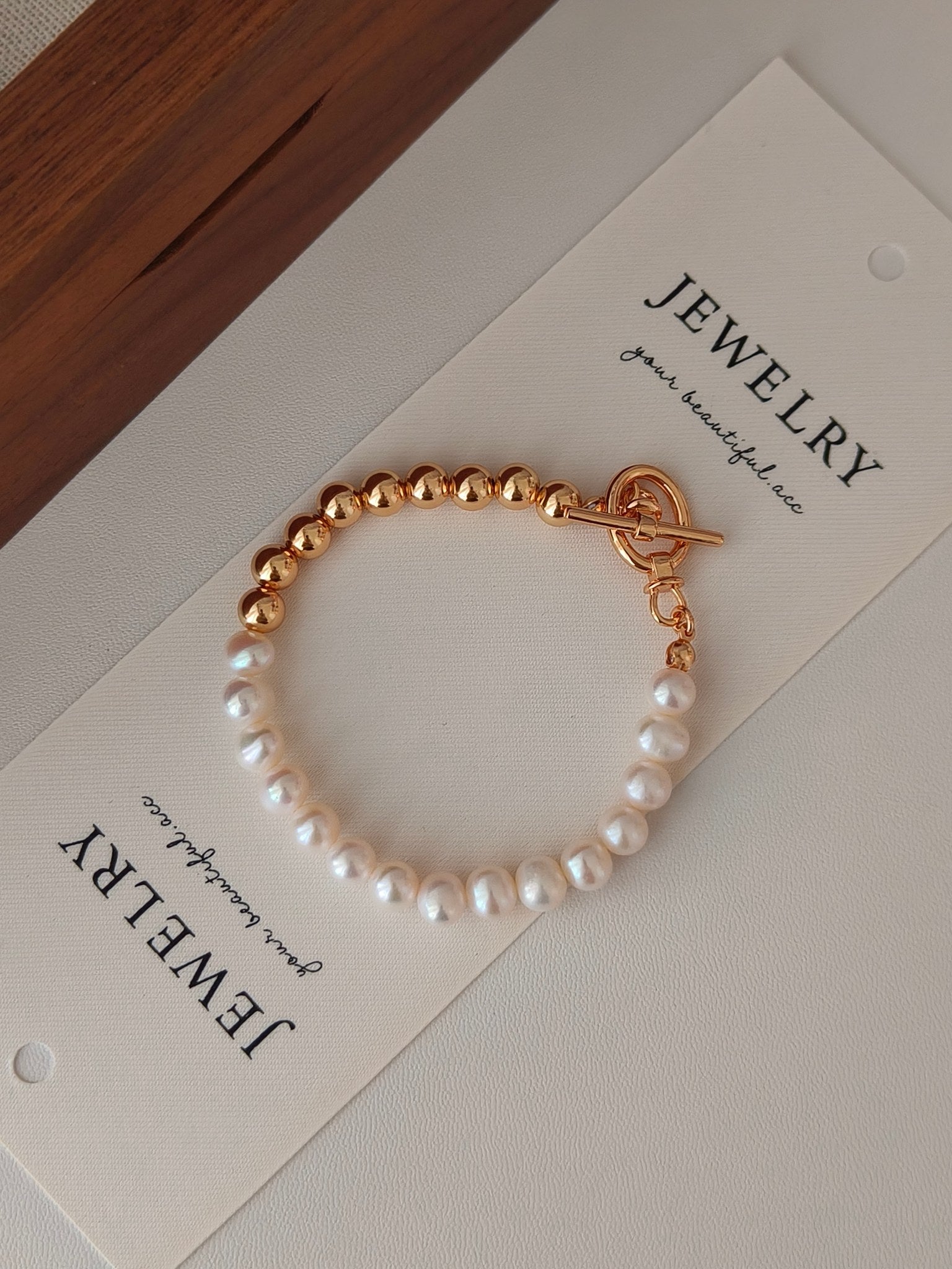 Gold-accented freshwater pearl bracelet with white pearls and round bead links