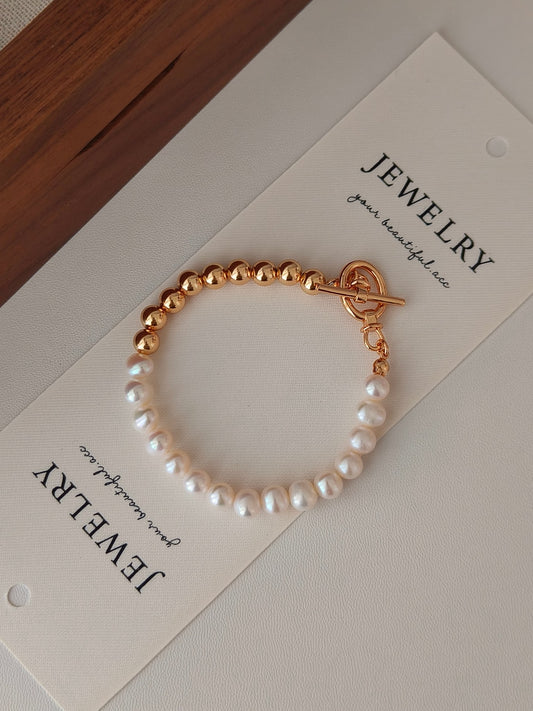Gold-accented freshwater pearl bracelet with white pearls and round bead links