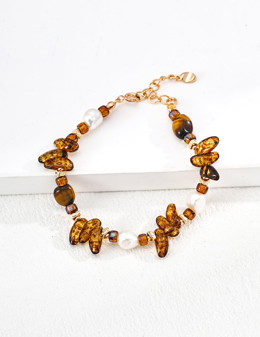 Gold-tone bracelet with amber tiger eye beads and white pearl accents