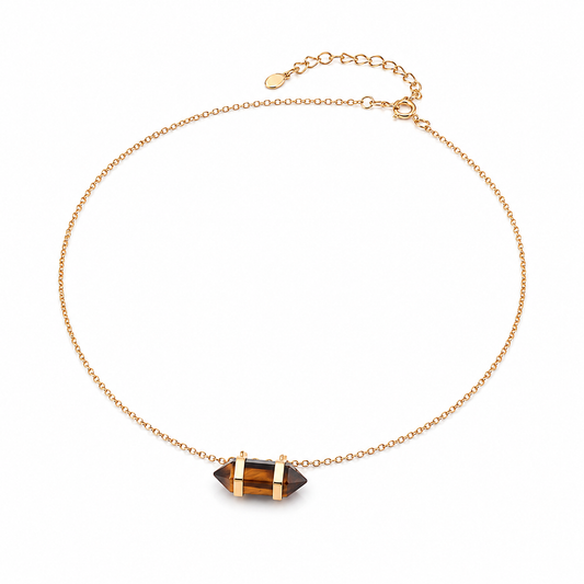 Gold chain necklace with centered dark geometric stone pendant