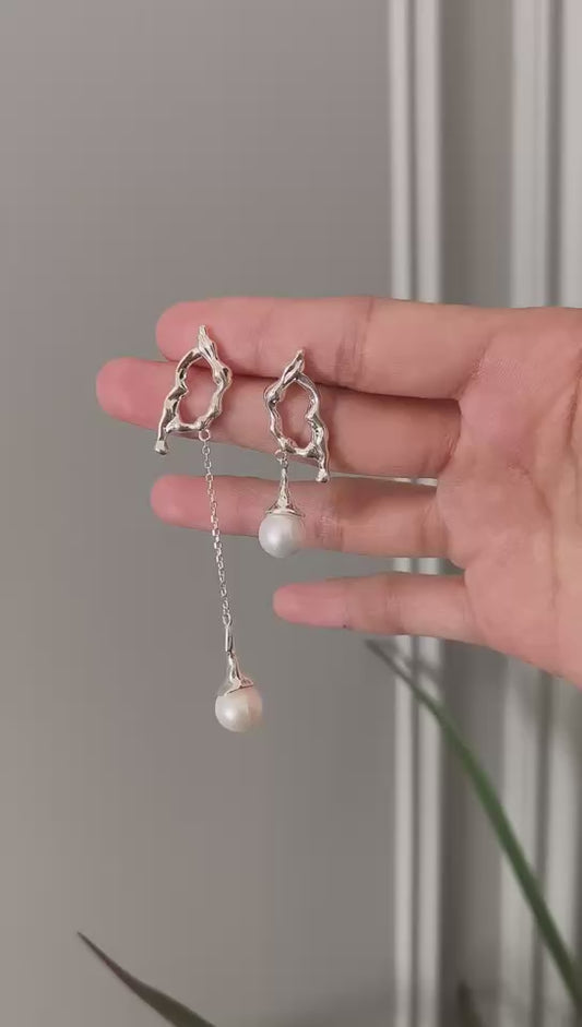 Tui in flight pearl earrings showing silver bird charms and two hanging white pearls