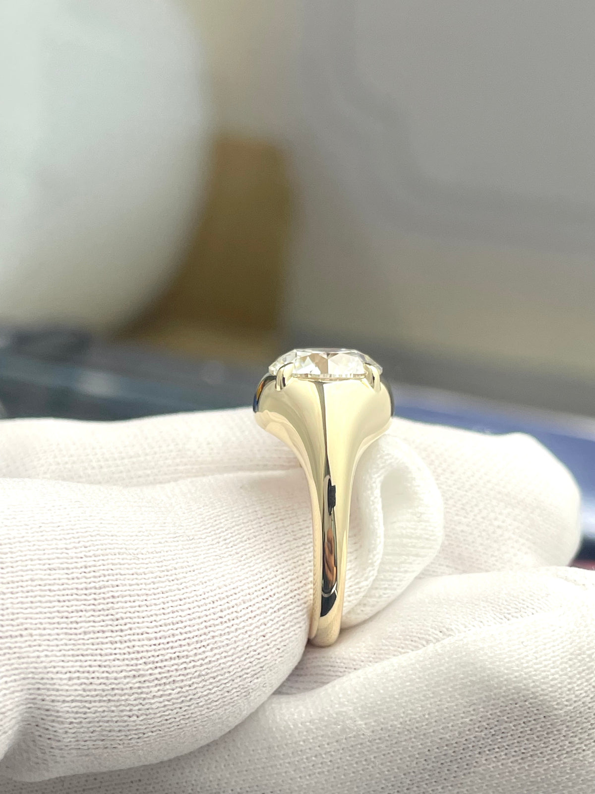 Yellow gold round diamond ring with raised bezel setting