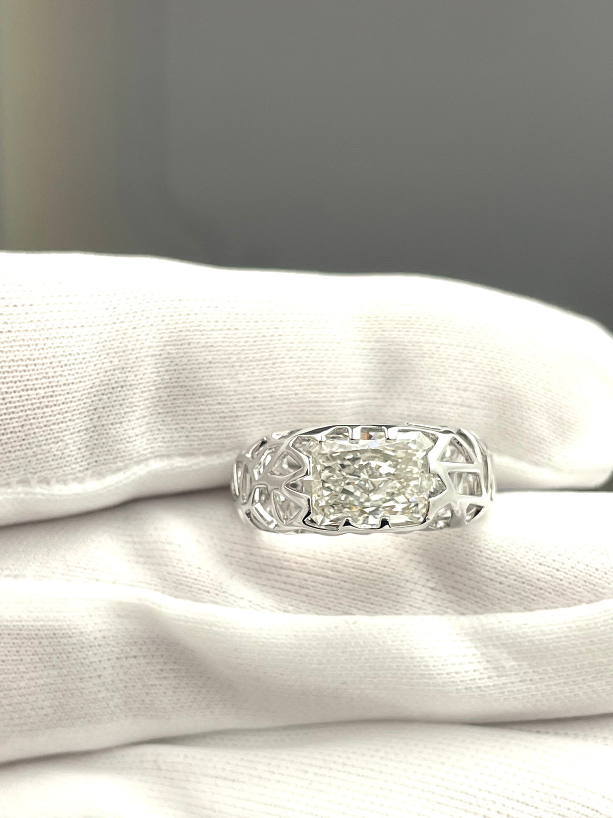 Silver bird-nest lab diamond ring with emerald-cut center stone and filigree sides
