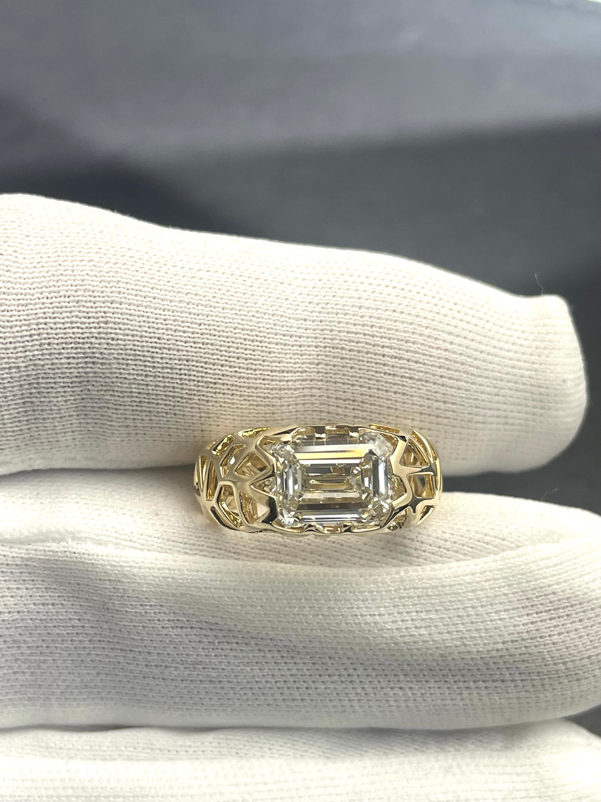 Tūī Bird Nest ring with emerald-cut clear center stone and gold band