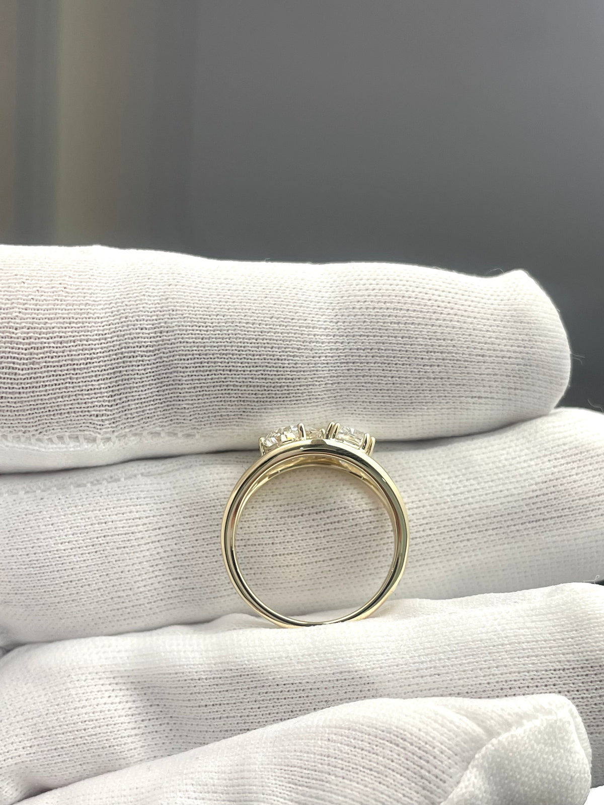 Lab diamond ring with slender gold band and prong-set stones, side view